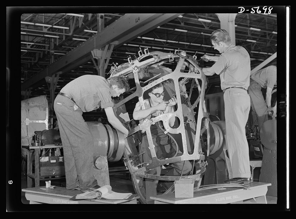 Production. Willow Run bomber plant. Advanced assembly includes riveting and drilling the nose of the bomber made in the…