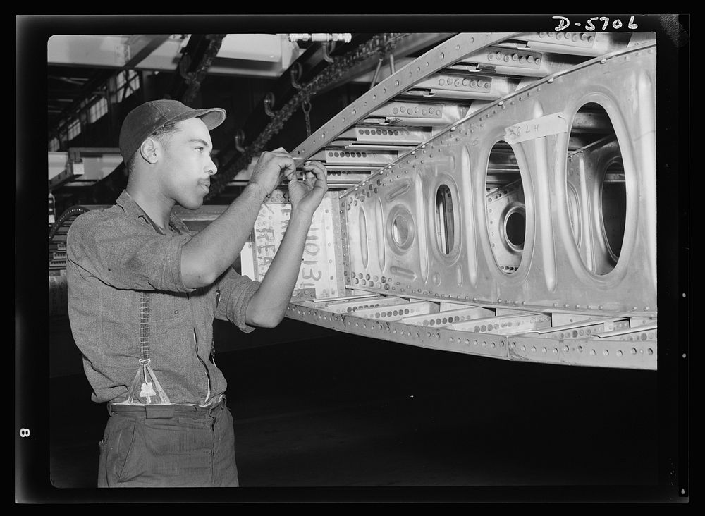 Production. Willow Run bomber plant. An African American worker at the giant Willow Run bomber plant installs screws in one…