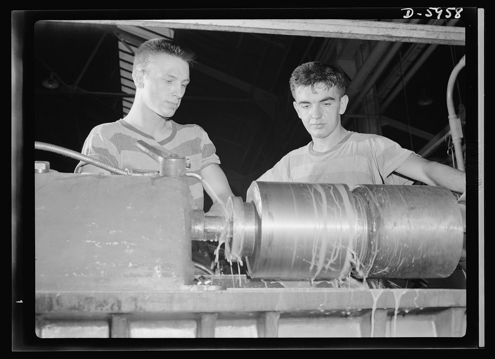 Manpower. Americans all. Operating a low-swing engine lathe, Joe Zorich (left) and Chuck Doe, both nineteen, are typical of…