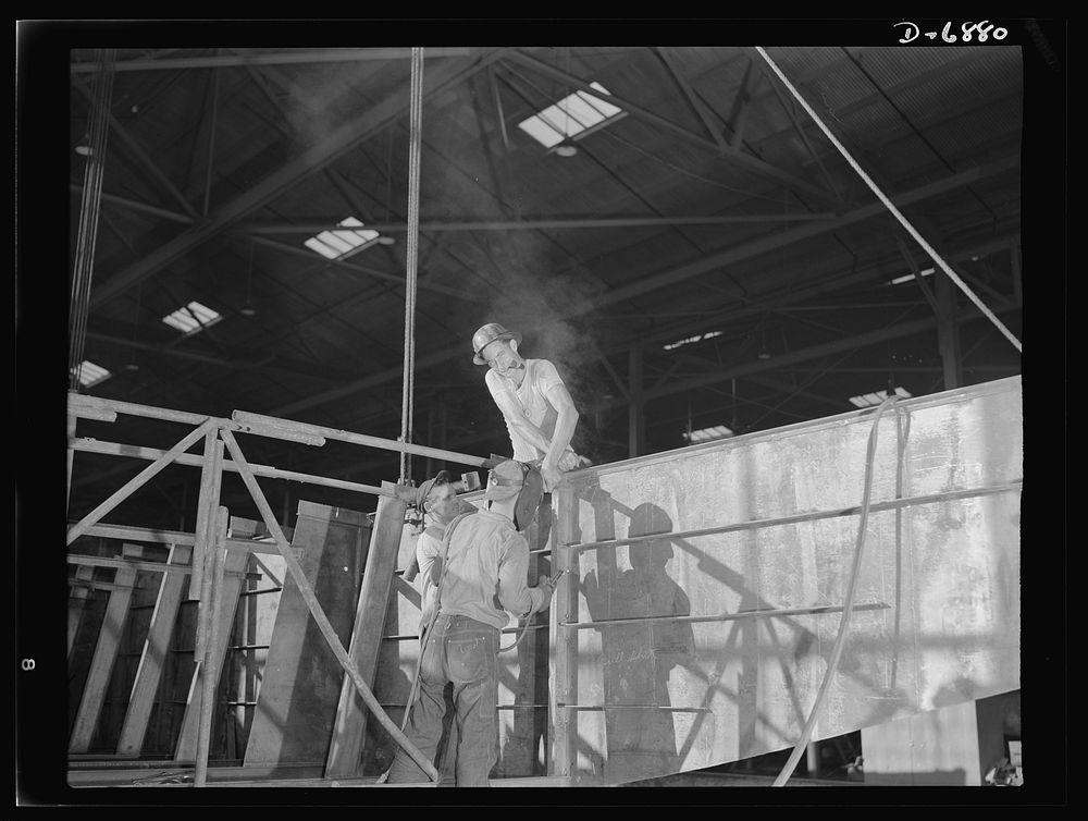 Production. Fifty-foot steel ramp boats. Working on the gunwale of a fifty-foot steel ramp boat used to land men, tanks and…