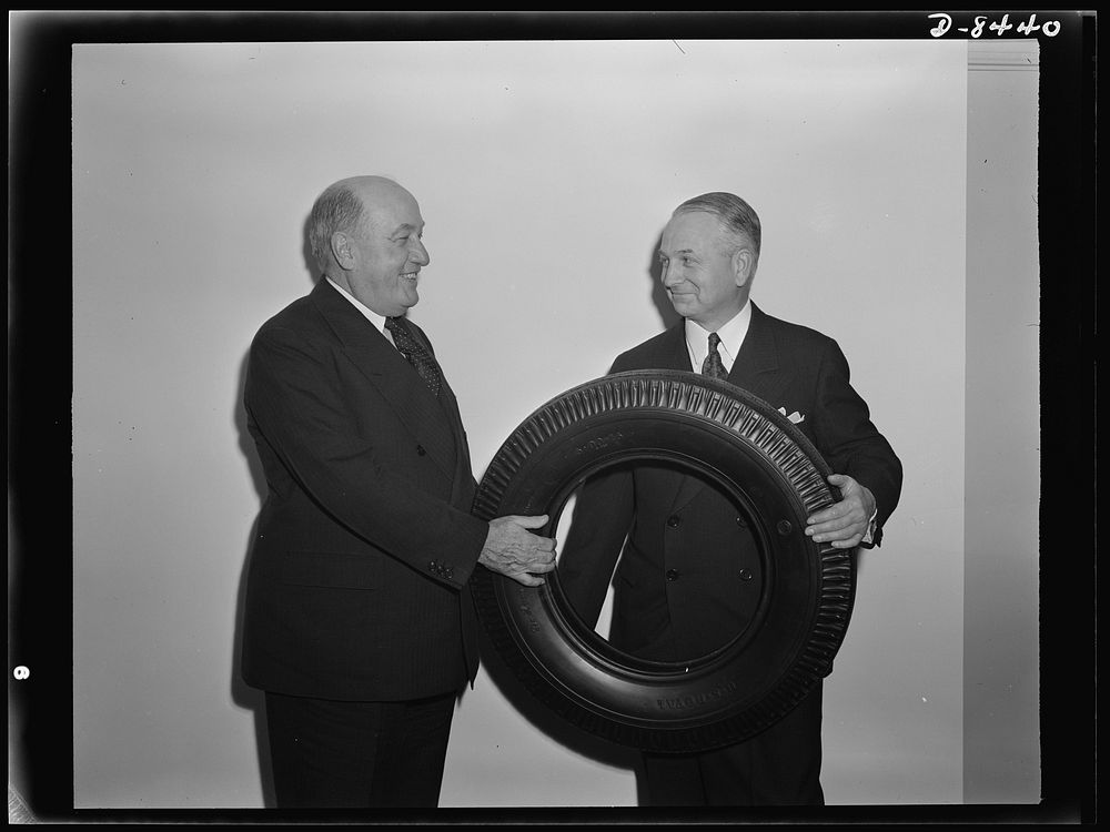 Tire made entirely of reclaimed rubber. F.S. Carpenter, of the United States Company, displays an automobile tire made…
