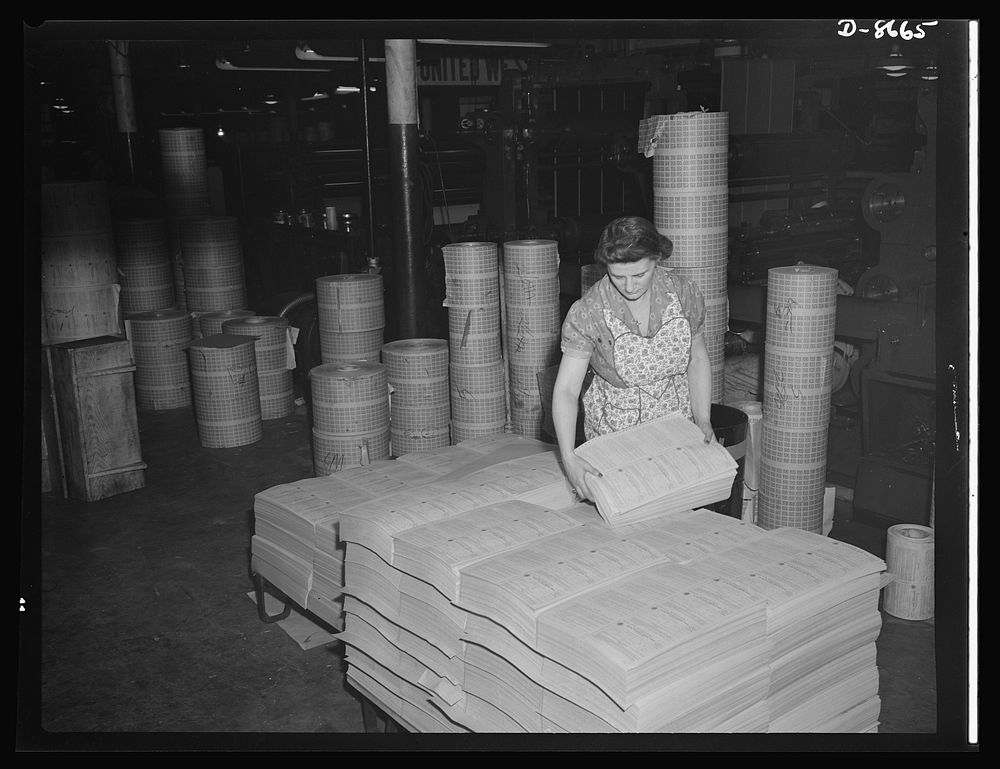 Printing war ration book 2. Jessie Calabase stacks the sheets containing four coupon books as they come from the collator…