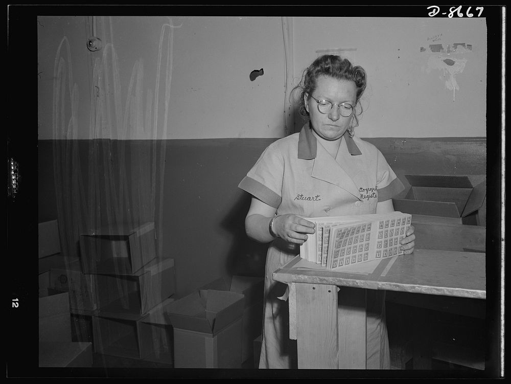 Printing war ration book 2. Ida Stuart quickly checks the assembled pages of ration books as they come from the cutter.…