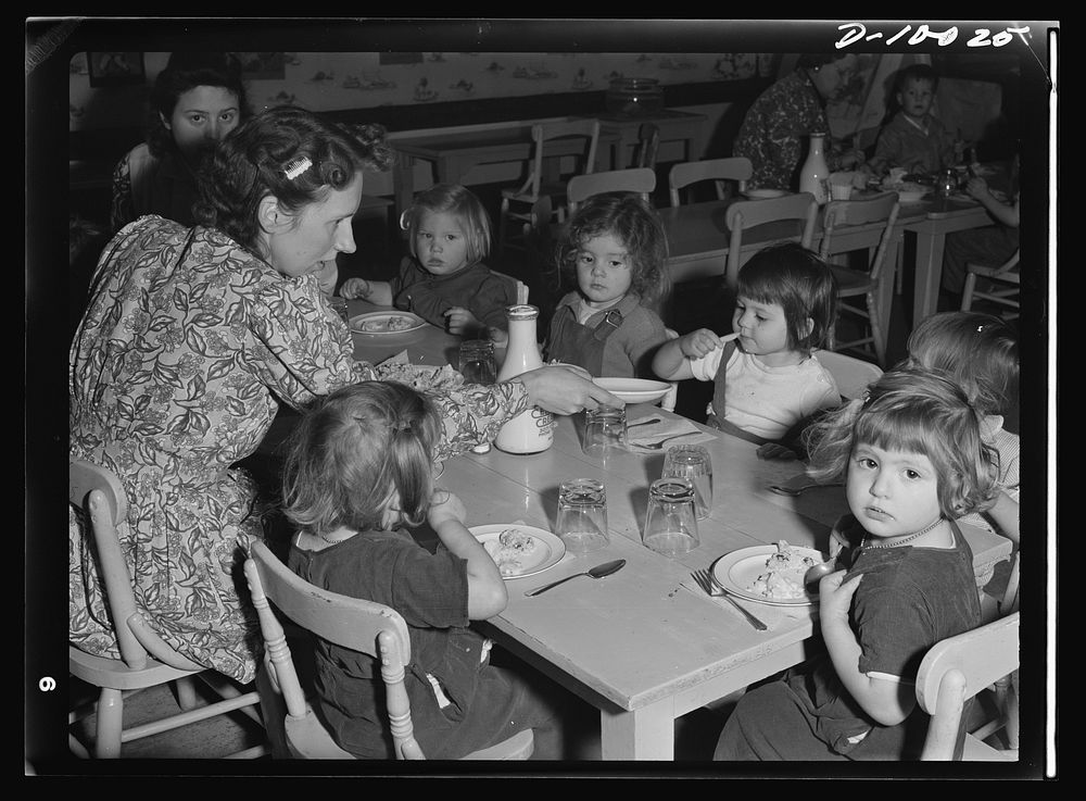 War workers' nursery. A young supervisor at the Bella Vista Nursery School in Oakland, California, eats luncheon with the…
