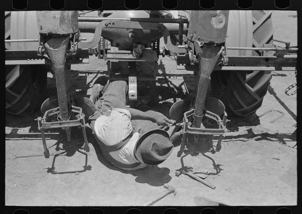 Adjusting plow points on tractor-drawn planter, large farm near Ralls by Russell Lee