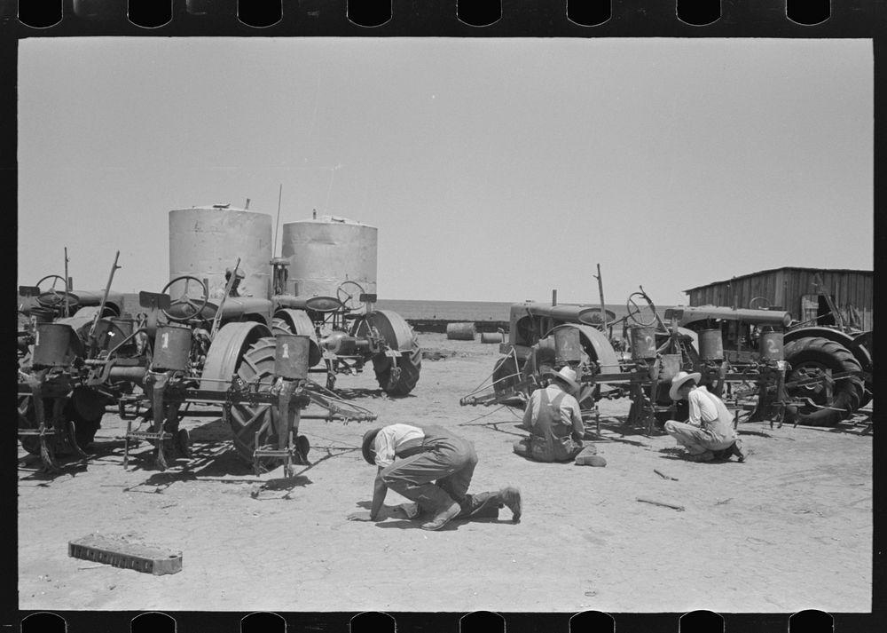 Part of the nine tractors on large farm near Ralls, Texas. The men working on them are day laborers who, with their…