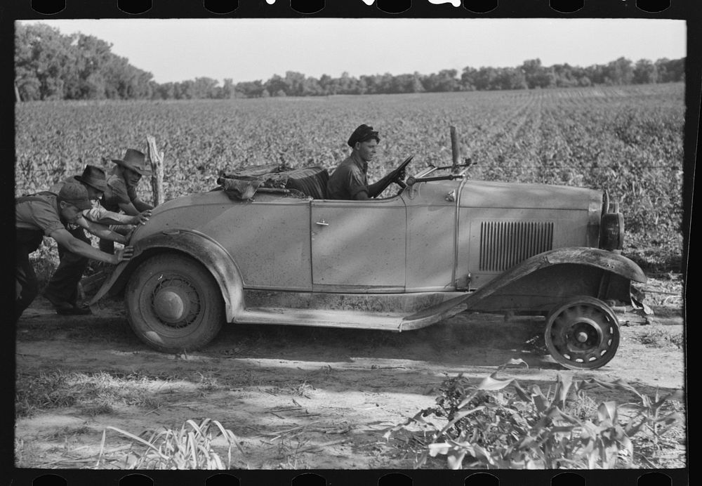 [Untitled photo, possibly related to: Pushing a car belonging to agricultural day laborer to start it, near Muskogee…
