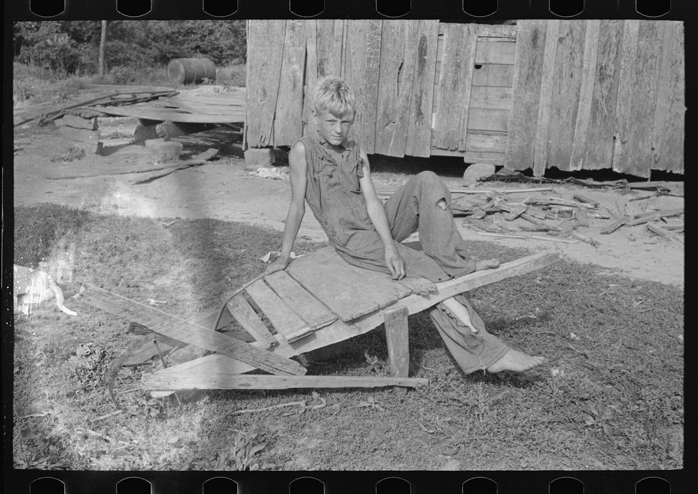 Son of day laborer resting on a wheel barrow, McIntosh County, Oklahoma by Russell Lee