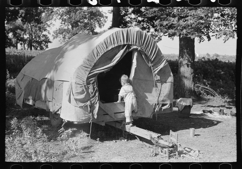 Child of white migrant going into covered wagon trailer, Wagoner County, Oklahoma by Russell Lee