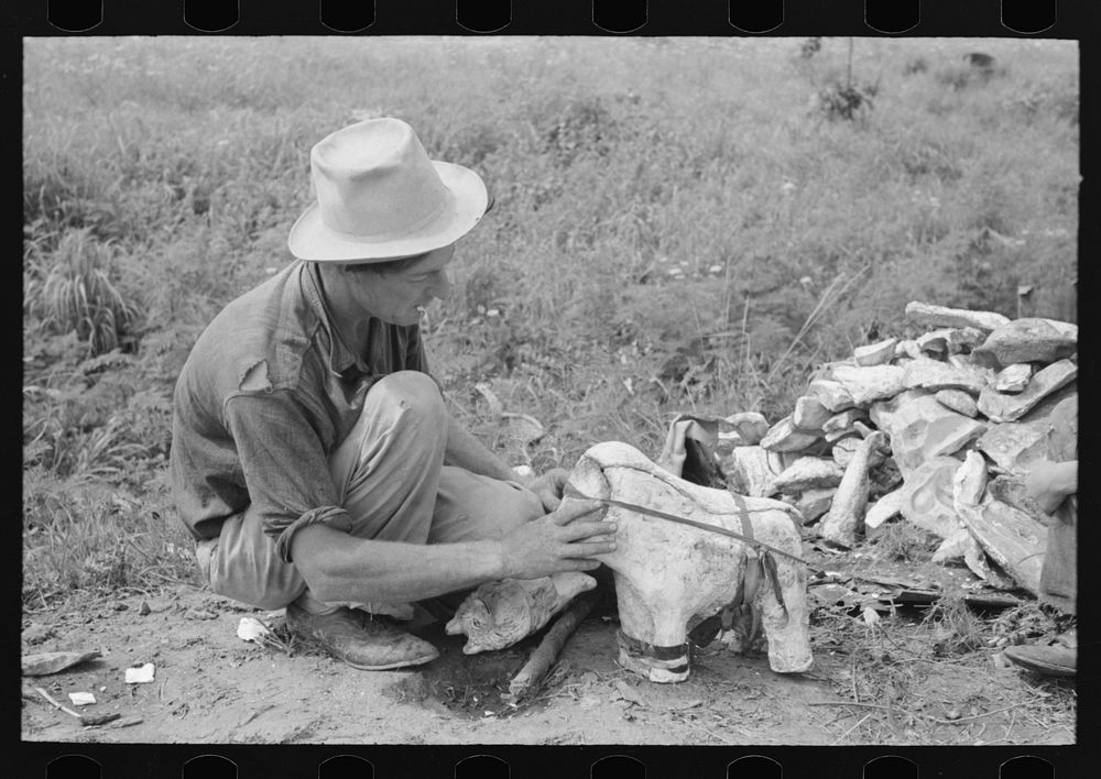 Itinerant statue maker putting together the pieces of a mold for one of his statues. He had been at one time an oil field…