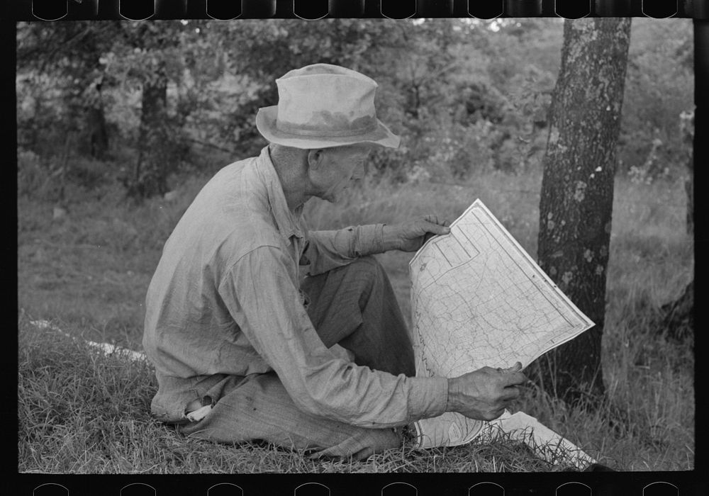 [Untitled photo, possibly related to: White migrant agricultural worker from Texas studying the map while stopped for lunch…