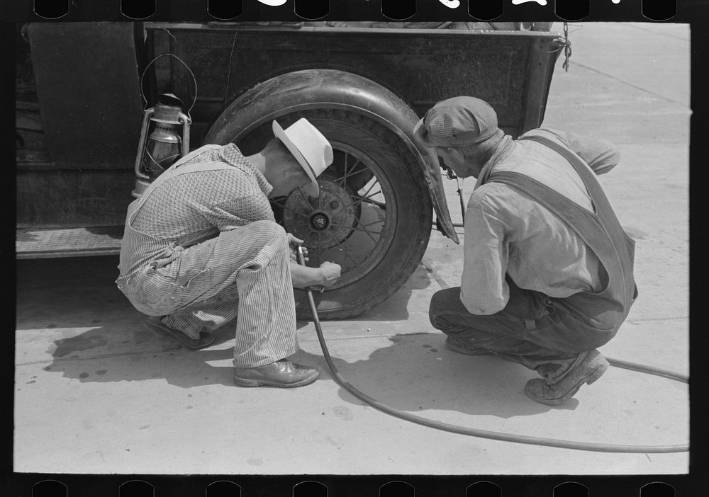 Migrants on the road checking tires at filling station near Henrietta [i.e., Henryetta,] Oklahoma by Russell Lee