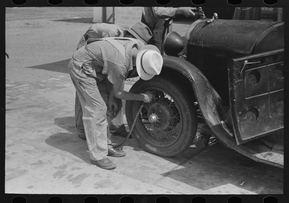 [Untitled photo, possibly related to: Migrants on the road checking tires at filling station near Henrietta [i.e.…