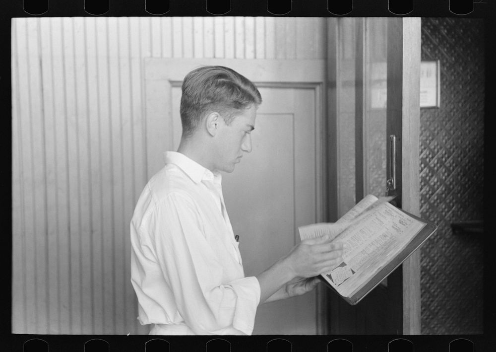 Man looking up telephone number. Streetcar terminal, Oklahoma City, Oklahoma by Russell Lee