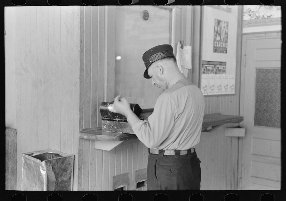[Untitled photo, possibly related to: Motorman with lunch basket making out reports. Streetcar terminal, Oklahoma City…