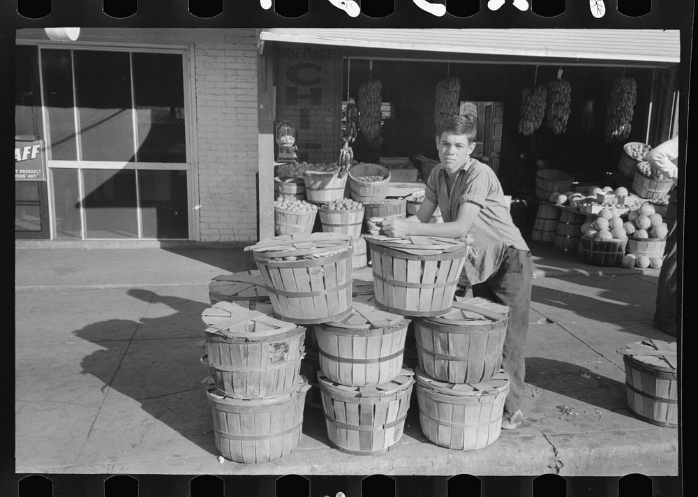Grocery boy leaning on basket of peaches, Muskogee, Oklahoma by Russell Lee
