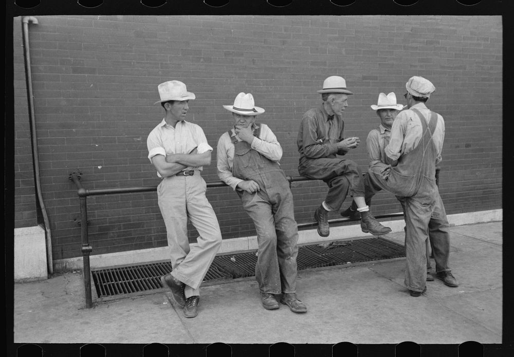 Group of men talking while sitting and leaning on railing, Muskogee, Oklahoma by Russell Lee