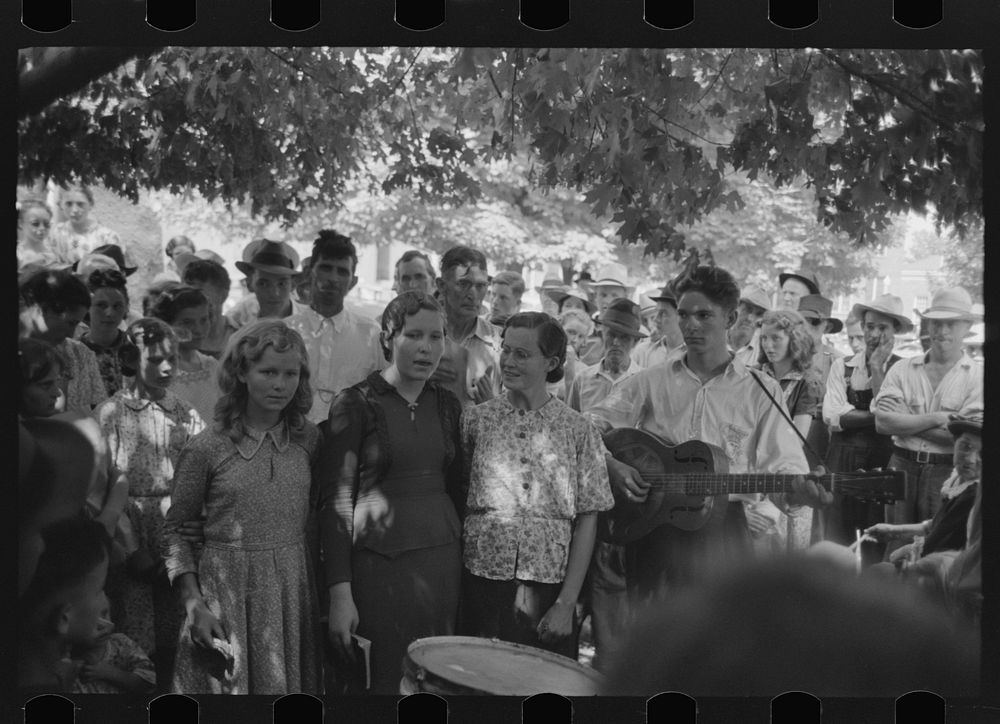 Revivalist singing at rally under trees in square, Saturday afternoon, Tahlequah, Oklahoma by Russell Lee