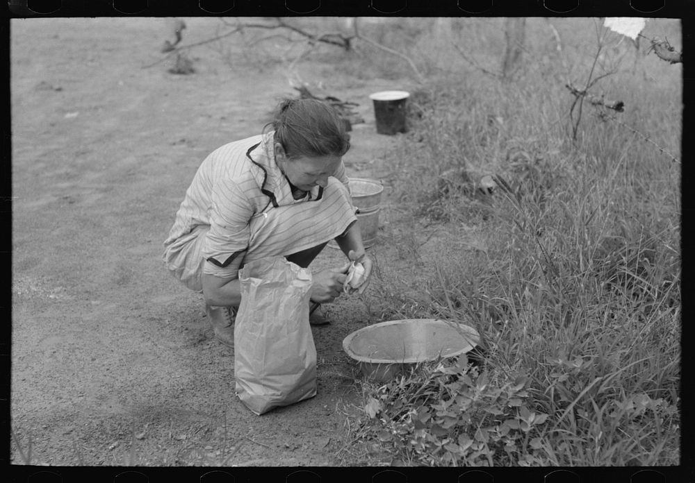 Woman of migrant family peeling potatoes near Henrietta [i.e., Henryetta,] Oklahoma by Russell Lee