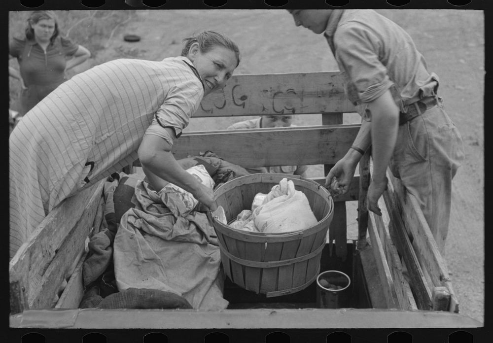 Removing victuals and groceries from the improvised truck at campfire near Henrietta [i.e., Henryetta,] Oklahoma. This is a…