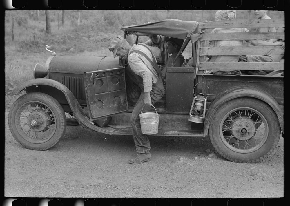 [Untitled photo, possibly related to: Migrant getting out of car with pail to get some water. Encamped along roadside near…