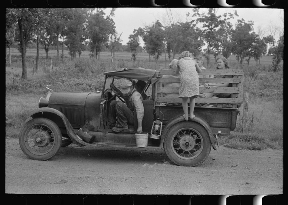 Migrant getting out of car with pail to get some water. Encamped along roadside near Henrietta [i.e., Henryetta,] Oklahoma…