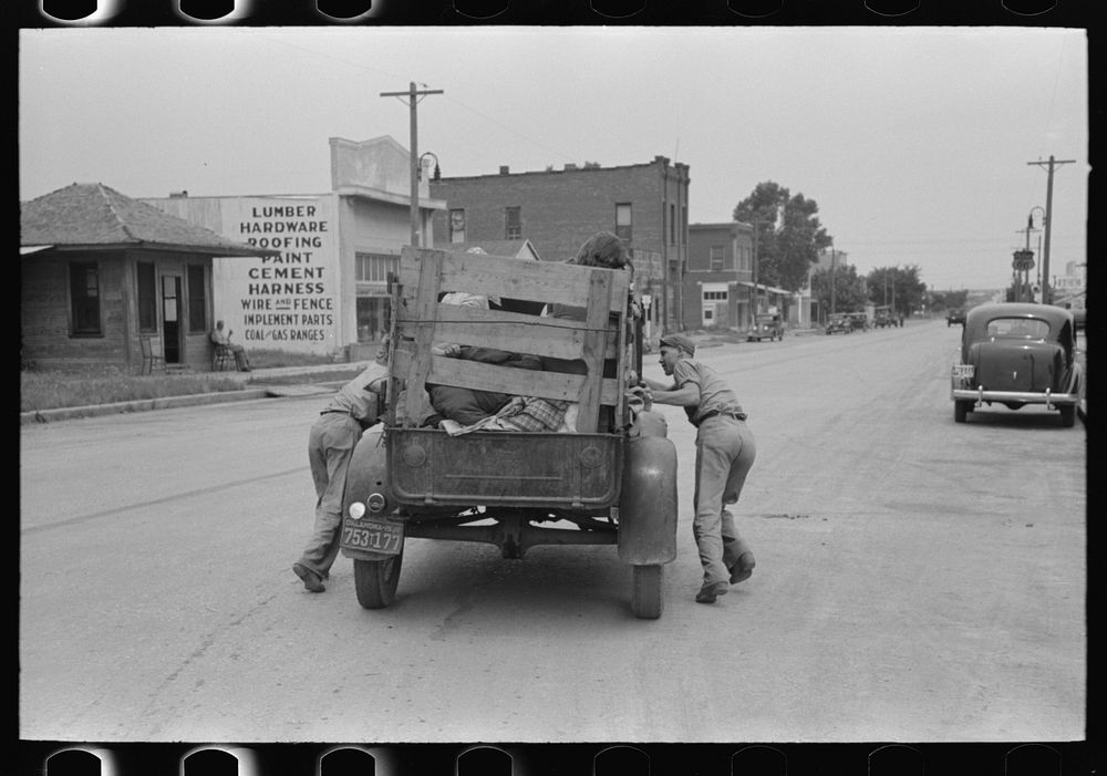 Pushing a truck of migrant family en route to California in order to get it started, near Henrietta [i.e., Henryetta,]…