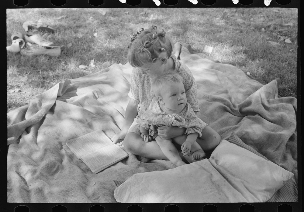 Little girl and her baby brother reading Bible, community camp, Oklahoma City, Oklahoma by Russell Lee