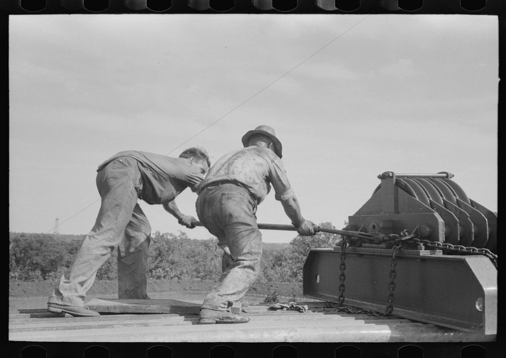 Unloading heavy equipment from truck, Seminole oil field, Oklahoma by Russell Lee