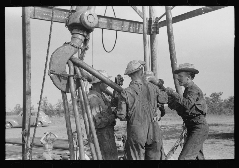 [Untitled photo, possibly related to: Oil workers working on lowered traveling block, Seminole oil field, Oklahoma] by…