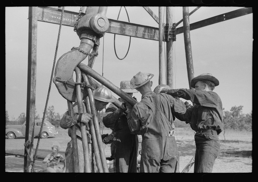 Oil workers working on lowered traveling block, Seminole oil field, Oklahoma by Russell Lee