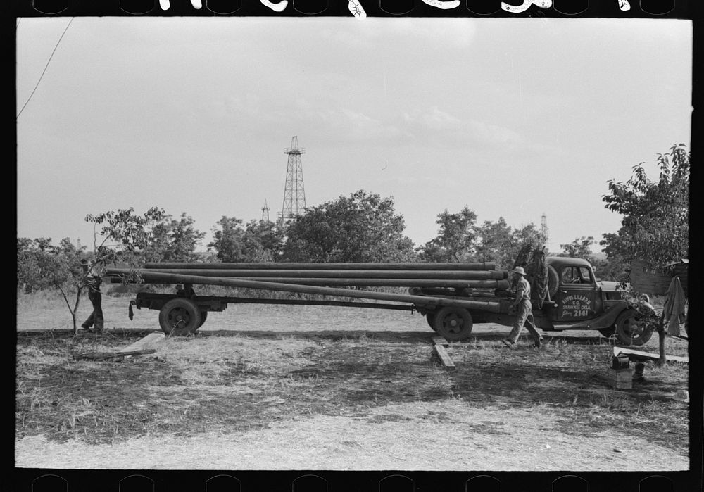 Unloading pipe from truck at oil well, Seminole oil field, Oklahoma by Russell Lee