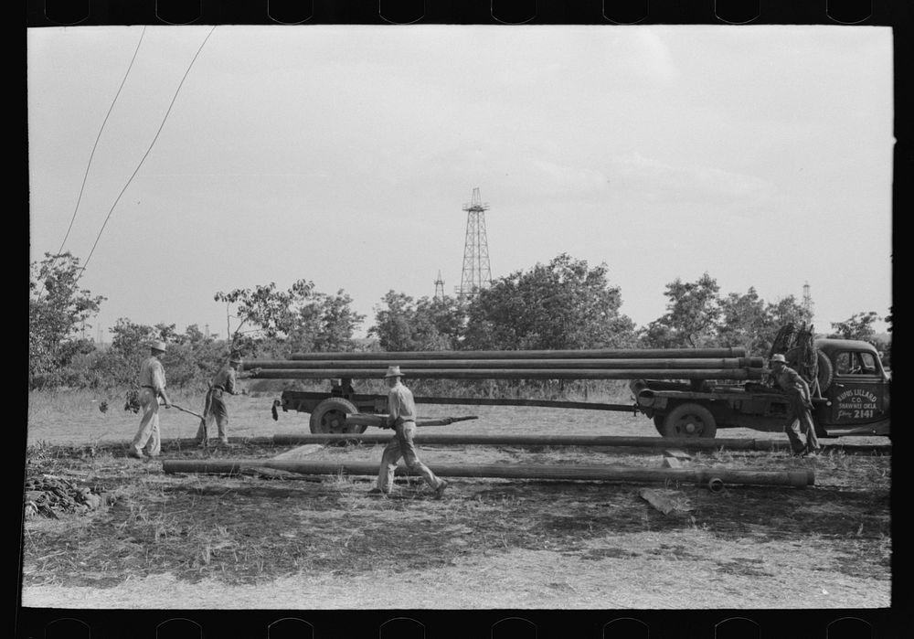 [Untitled photo, possibly related to: Unloading pipe from truck at oil well, Seminole oil field, Oklahoma] by Russell Lee
