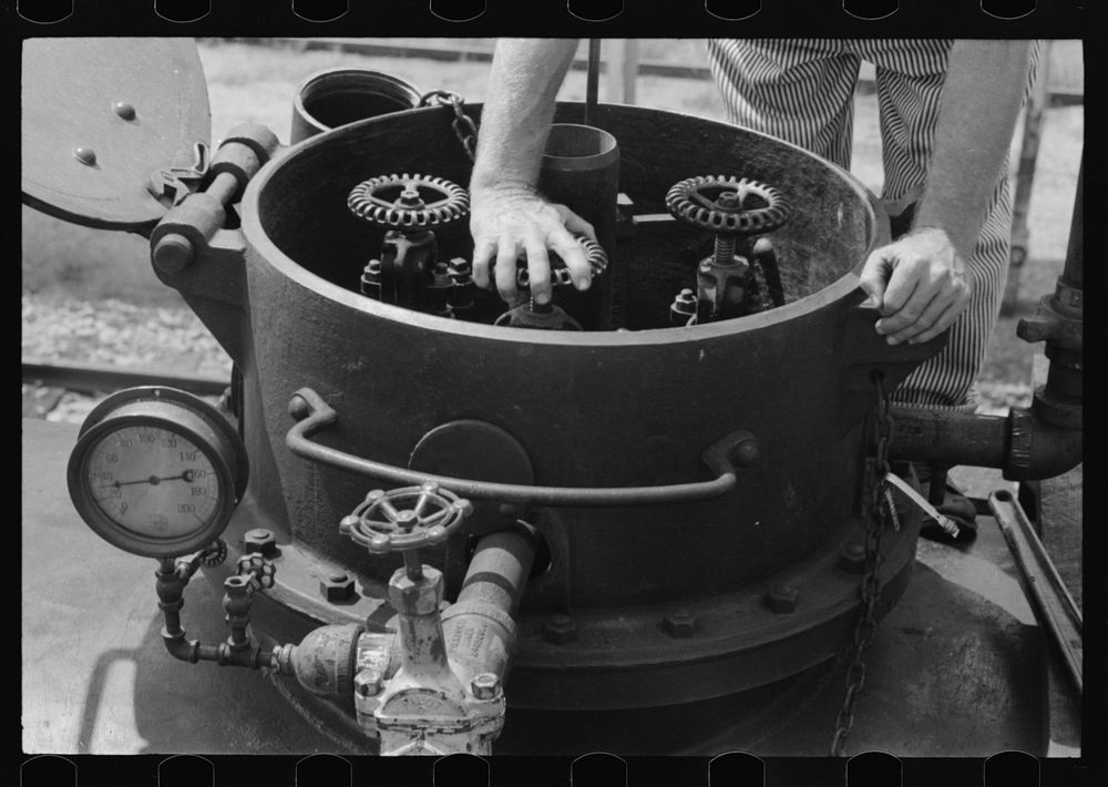 [Untitled photo, possibly related to: Opening the valves in a tank car containing gas, Seminole, Oklahoma] by Russell Lee