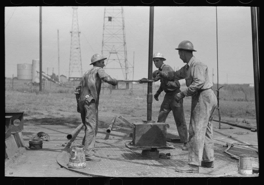 [Untitled photo, possibly related to: Roughnecks leaning on the wrench to tighten the joint in the pipe, oil well, Oklahoma…