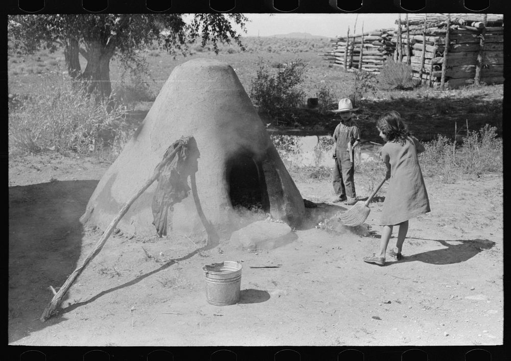[Untitled photo, possibly related to: Pulling out hot coals with wet cloth, Taos County, New Mexico] by Russell Lee