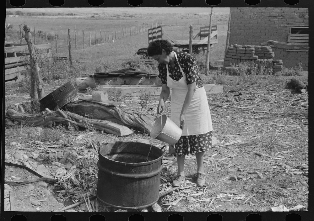 Spanish-American FSA (Farm Security Administration) client adding water to soap kettle, Taos County, New Mexico by Russell…