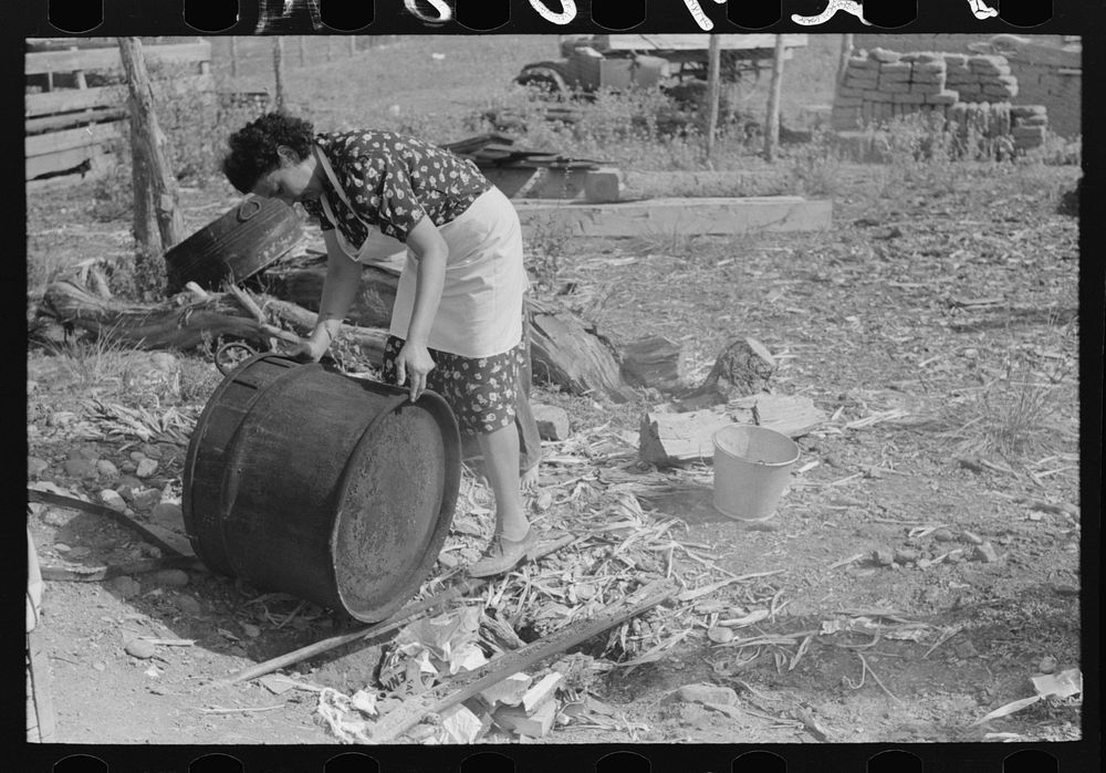 Spanish-American FSA (Farm Security Administration) client rinsing soap kettle before using, Taos County, New Mexico by…