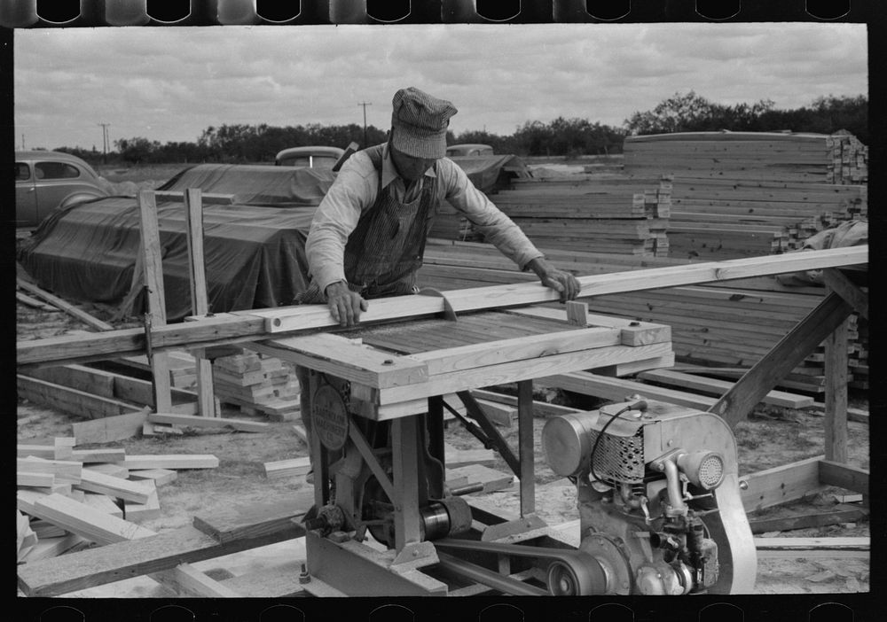 Cutting two-by-fours into identical lengths at migrant camp under construction at Sinton, Texas by Russell Lee