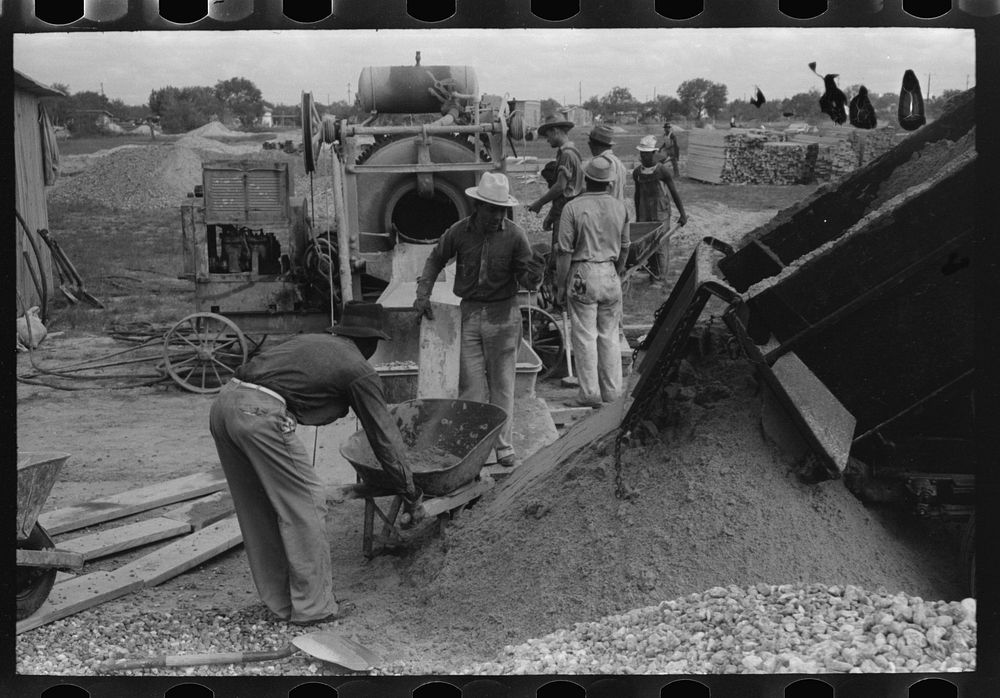 [Untitled photo, possibly related to: Activity around concrete mixer at migrant camp under construction at Sinton, Texas] by…