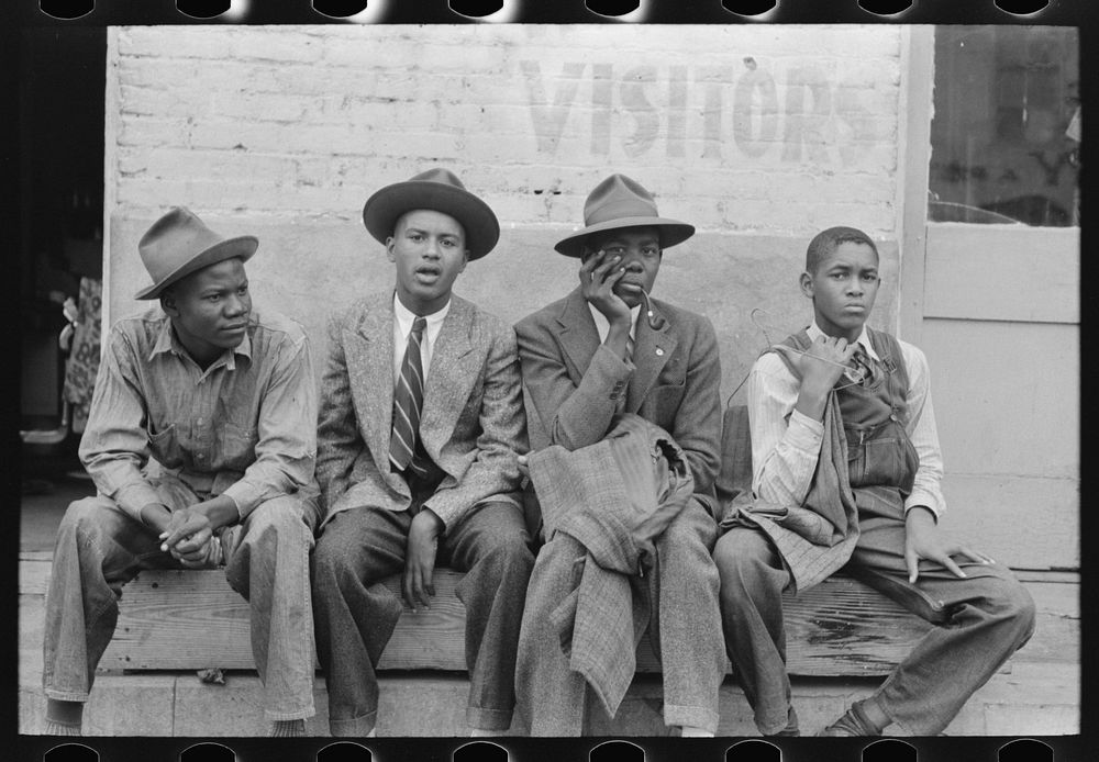 Boys sitting on bench on street, Waco, Texas by Russell Lee