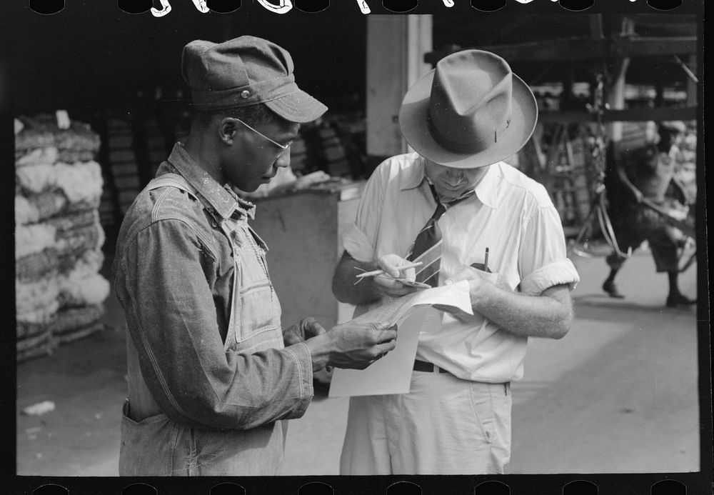 Trucker and weighing checker at unloading platform. Cotton compress, Houston, Texas by Russell Lee