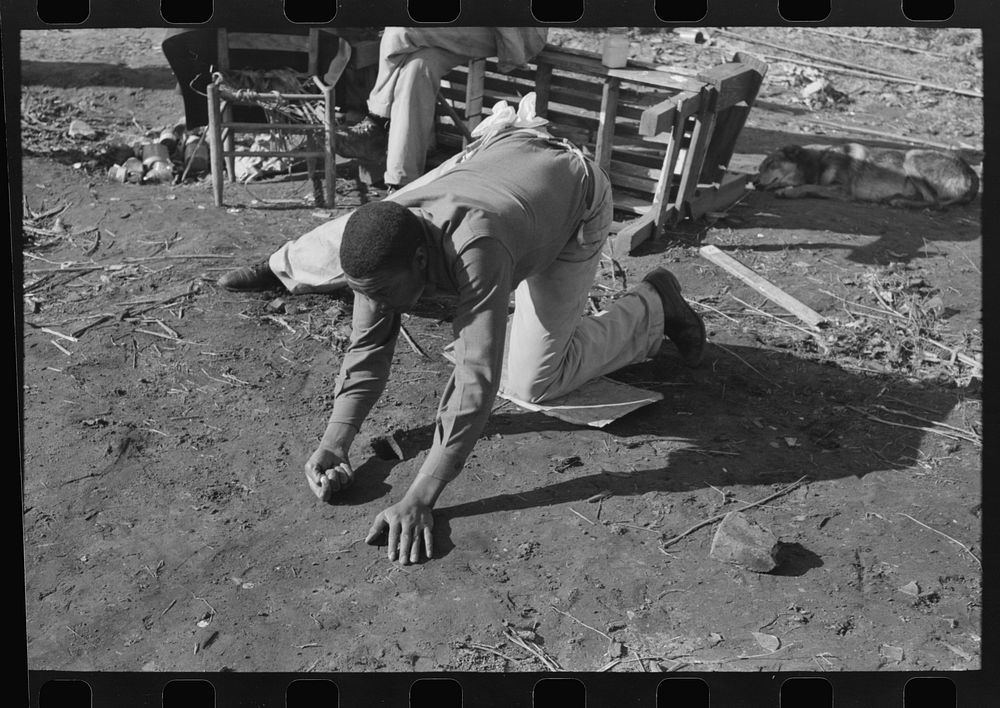 [Untitled photo, possibly related to:  playing marbles on the first warm day in the spring. In this game the players shoot…