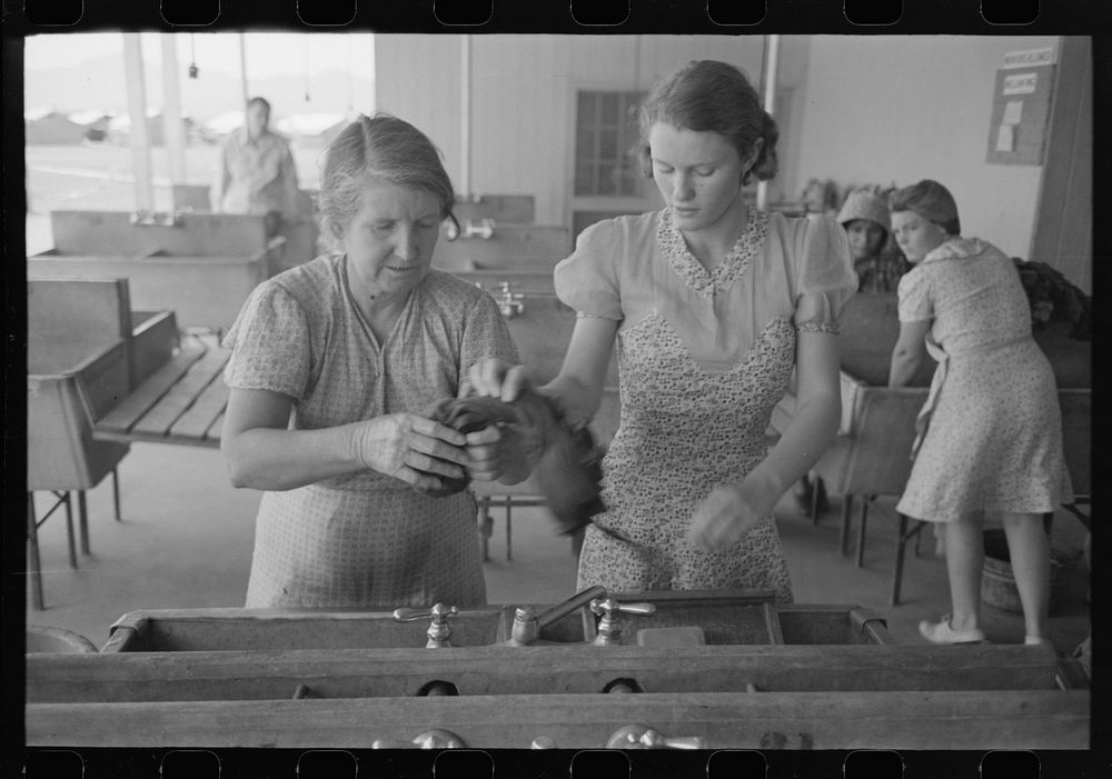 Wives of migratory laborers working in the laundry room at the Agua Fria Migratory Labor Camp, Arizona by Russell Lee