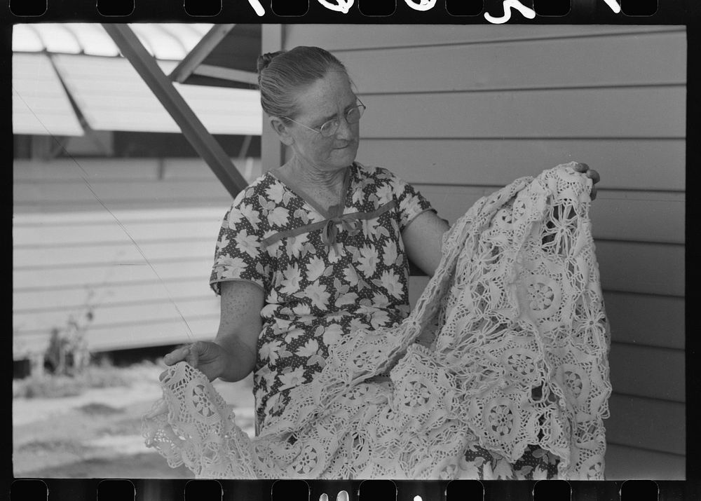 [Untitled photo, possibly related to: Wife of migratory worker looking at a crocheted bedspread which she made, Agua Fria…