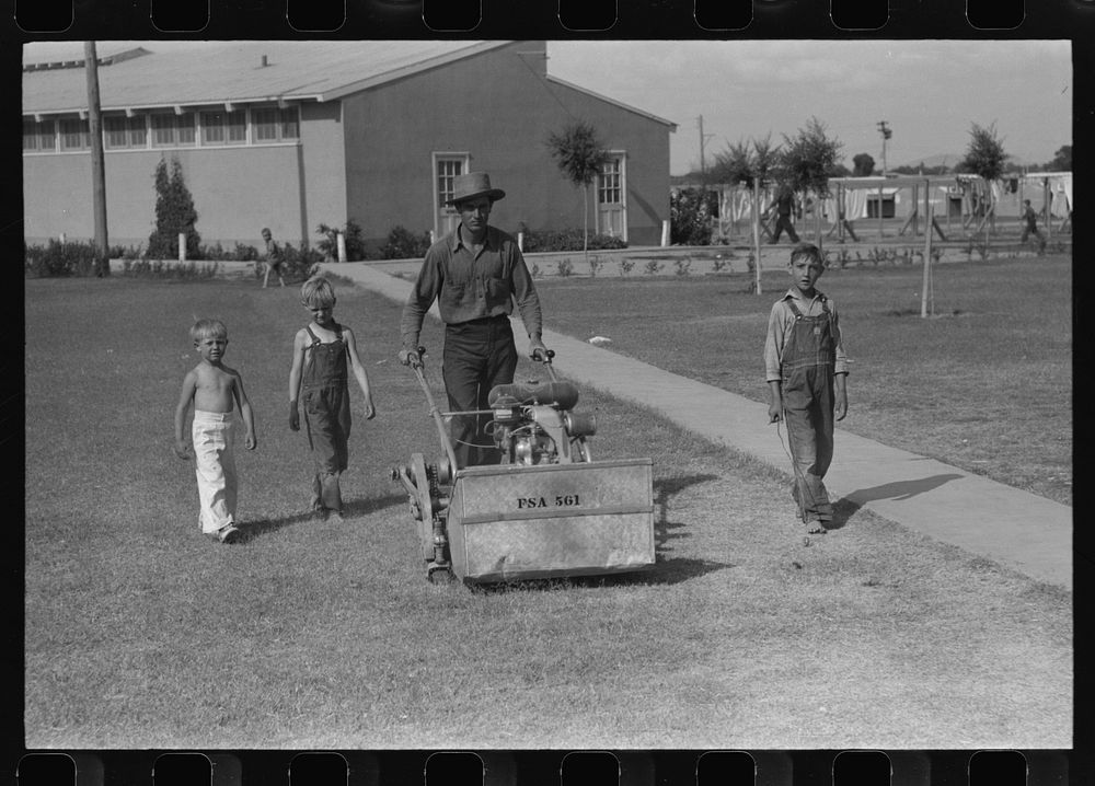 Worker mowing grass at the Agua Fria Migratory Labor Camp, Arizona by Russell Lee