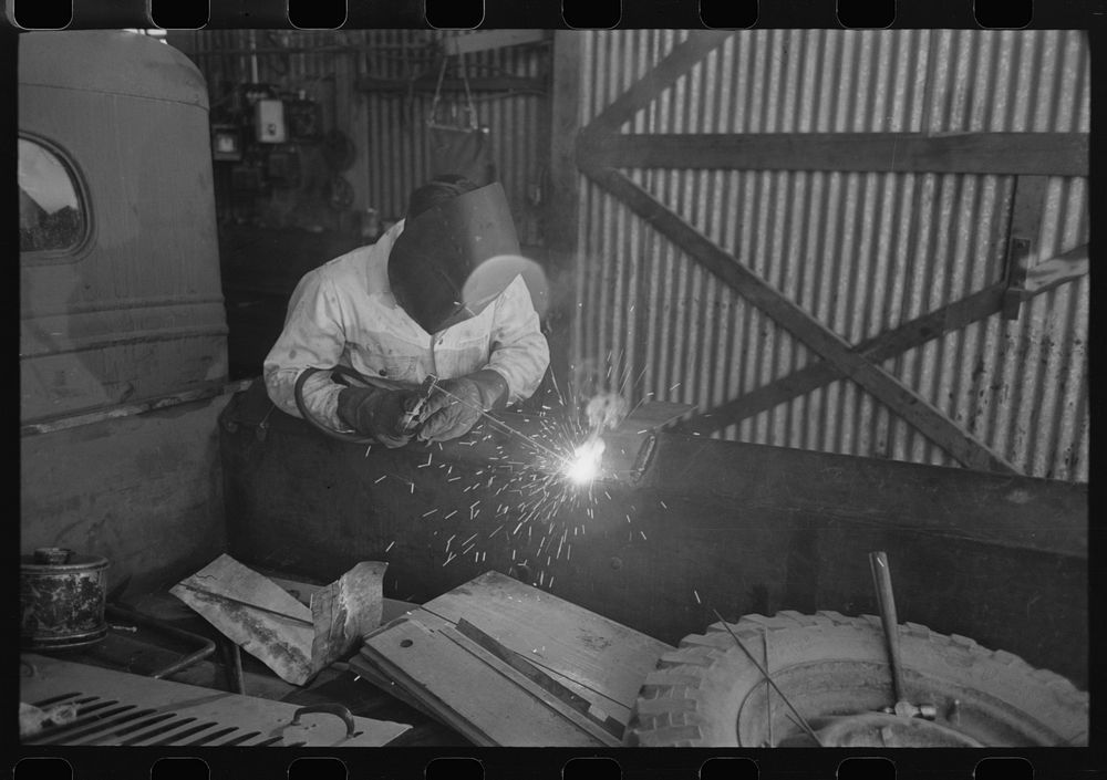 The United Producers and Consumers Cooperative maintains an automobile repair shop. In this picture, a worker is repairing a…