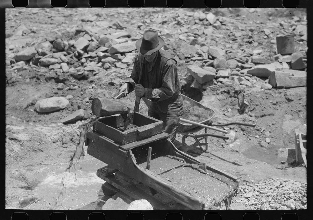 Gold prospector pouring water through his "rocker," Pinos Altos, New Mexico. He was born in Fremont, Nebraska on Eugene…