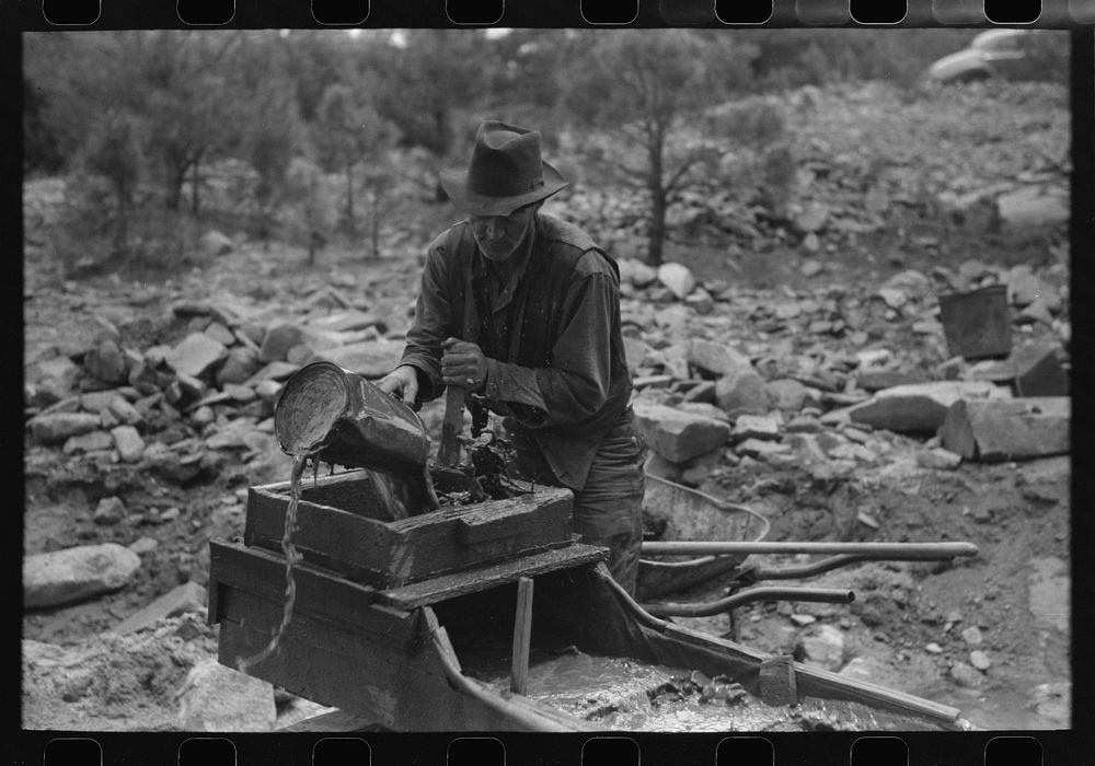 Gold prospector pouring water into "rocker," Pinos Altos, New Mexico by Russell Lee