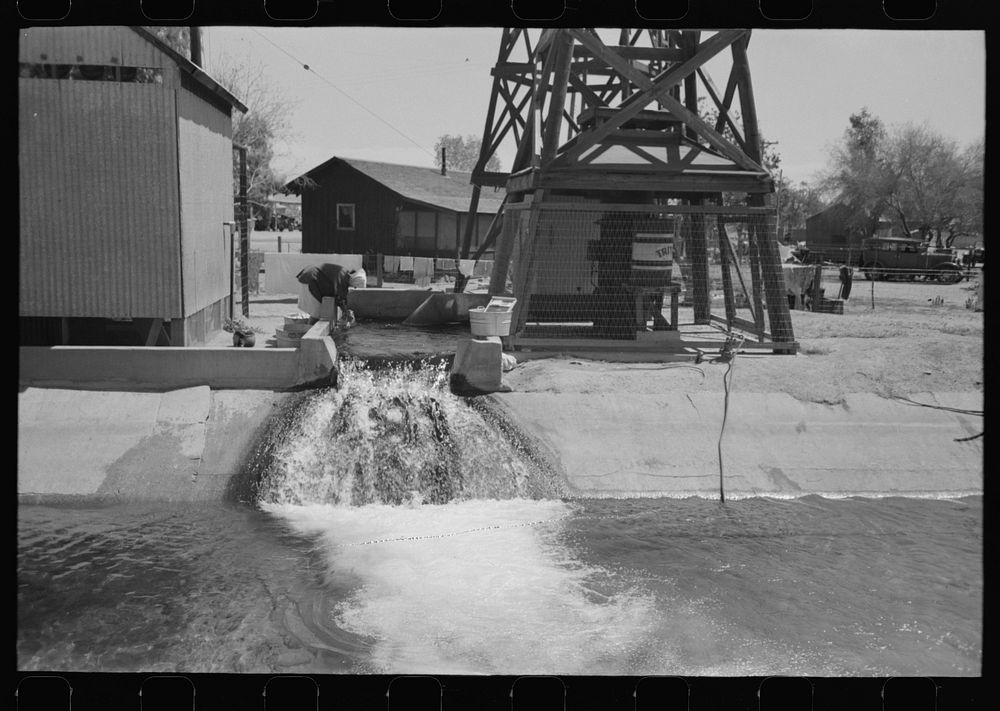 [Untitled photo, possibly related to: Woman washing clothes at deep well which also feeds the irrigation ditch, Maricopa…